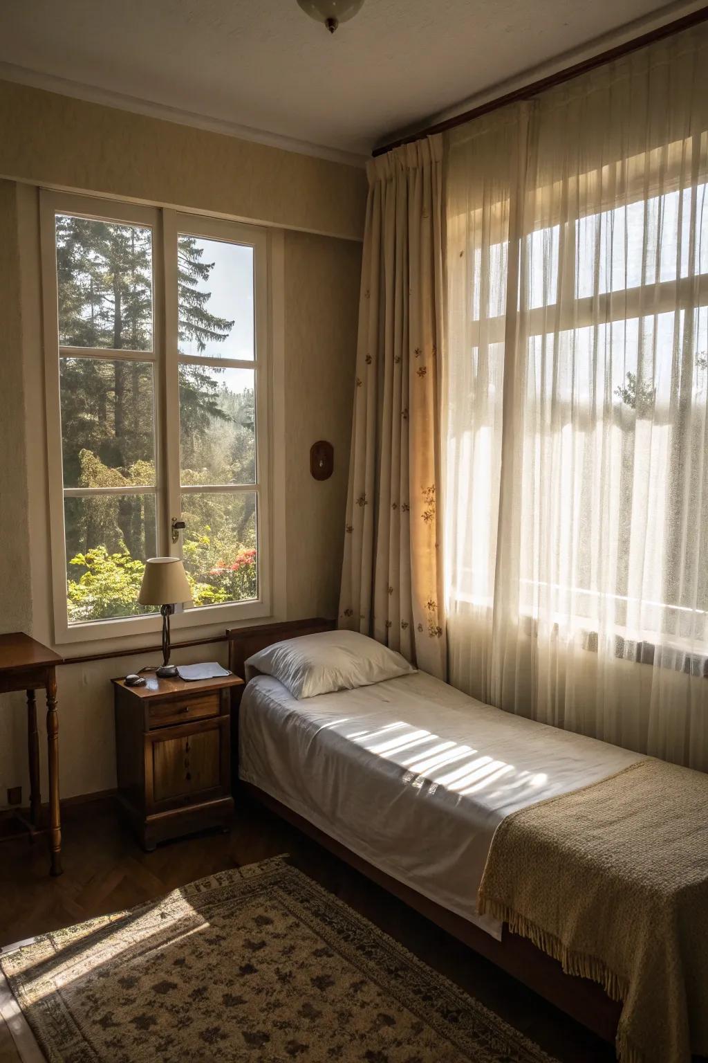 A small bedroom bathed in natural light through sheer curtains.