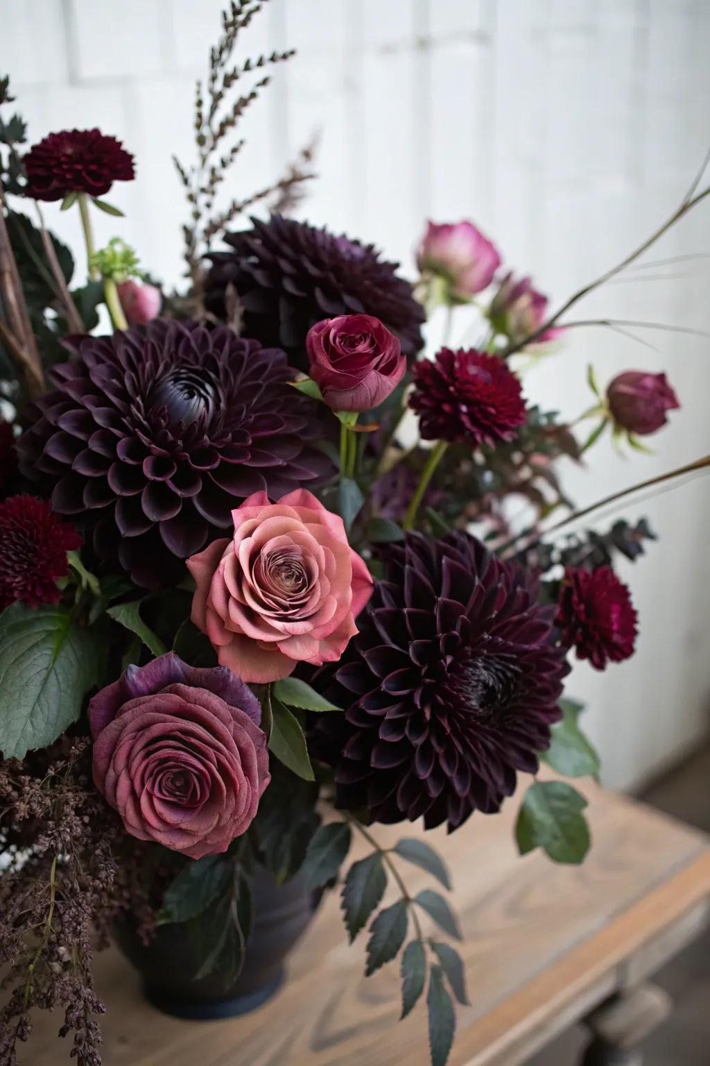 A moody bouquet with black dahlias and plum roses.