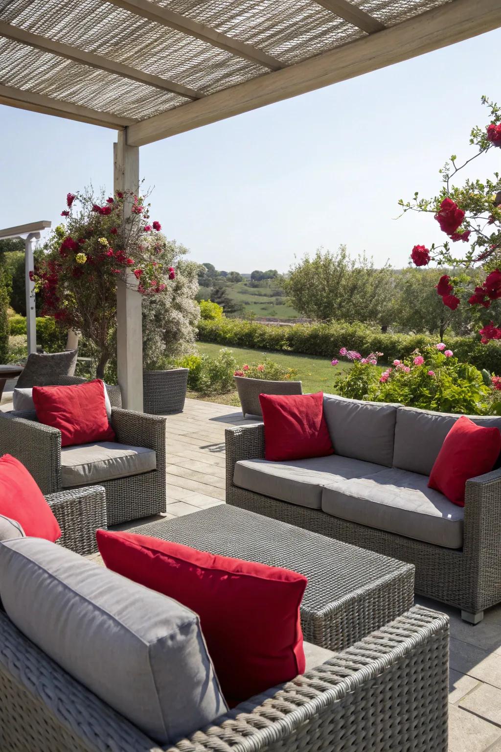 An outdoor patio featuring grey furniture and red cushions.